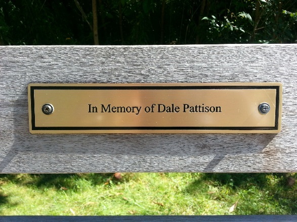 Plaque on a bench that says 